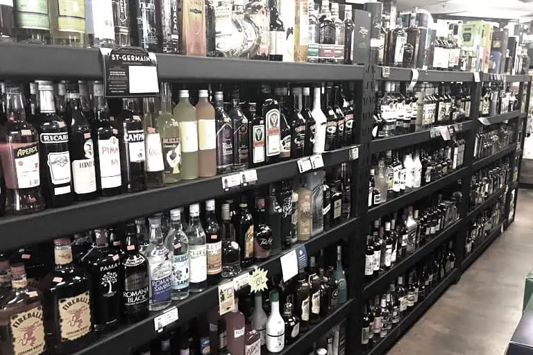 Liquor bottles on a store shelf. Many 50th birthday party themes feature an open bar for guests.