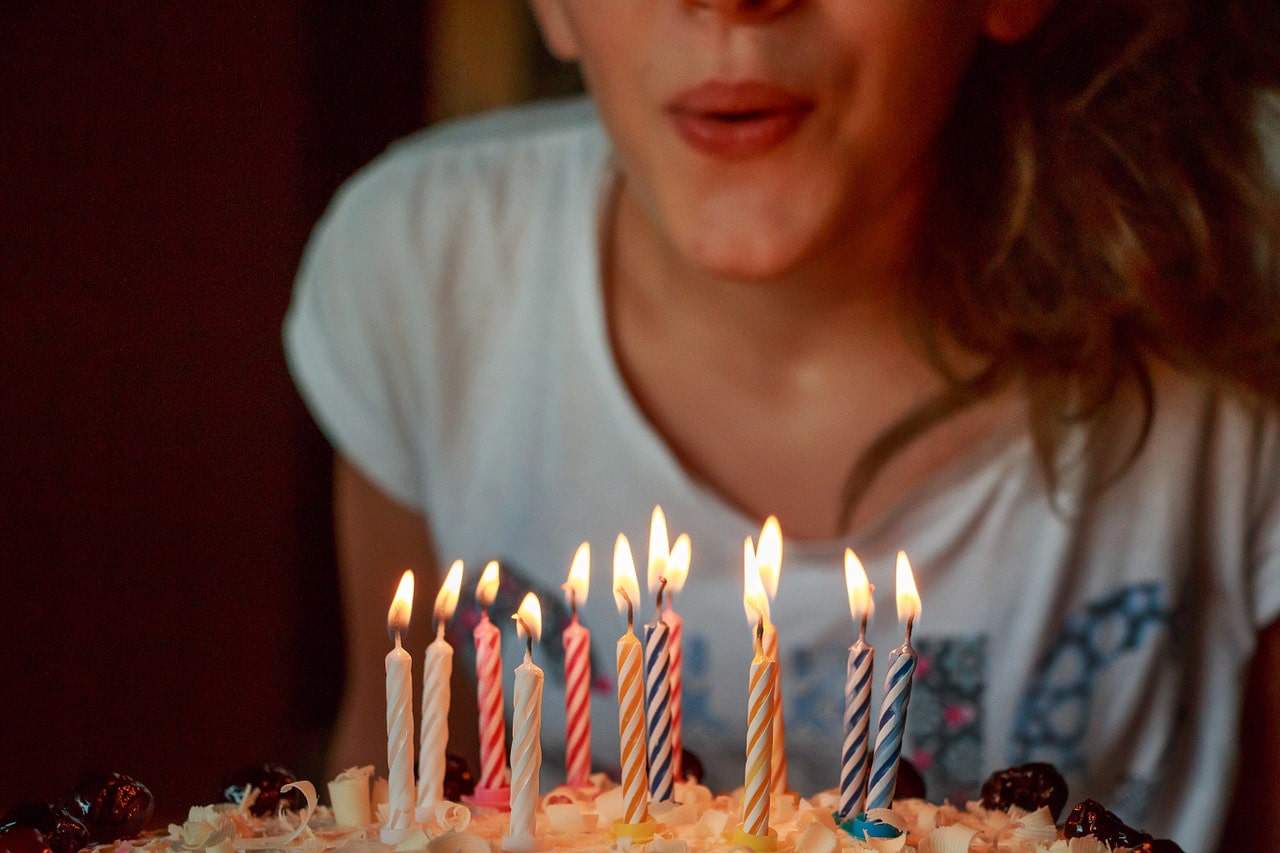 Girl blowing out candles on a birthday cake