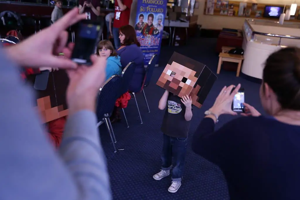 A kid wearing a MINECRAFT PARTY mask