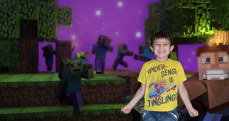 boy standing in front of a Minecraft image